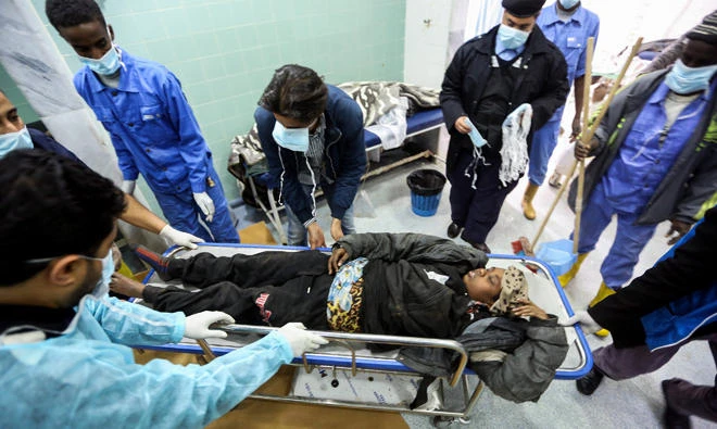 Libyan medical staffers tend to an African migrant that was injured after their vehicle was overturned during a truck collision near the town of Beni Walid, 170 kilometres southeast of the capital Tripoli, on Feb. 14, 2018. (AFP)