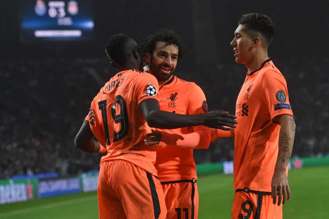 Liverpool's Senegalese midfielder Sadio Mane (L) celebrates with Liverpool's Egyptian midfielder Mohamed Salah and Liverpool's Brazilian midfielder Roberto Firmino (R) after scoring their third goal during the UEFA Champions League round of sixteen first leg football match against FC Porto. (AFP)