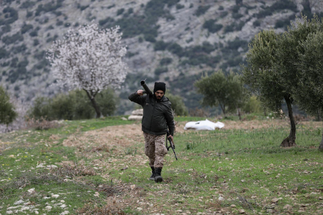 Turkish-backed Free Syrian Army fighter walks as he holds a weapon in Northern Afrin countryside, Syria, February 16, 2018. (Reuters)