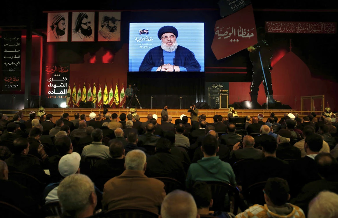 Hezbollah leader Sheik Hassan Nasrallah speaks on a screen via a video link during a ceremony to mark the anniversary of the death of Hezbollah leaders in the southern suburbs of Beirut, Lebanon, Friday, Feb. 16, 2018. (AP)