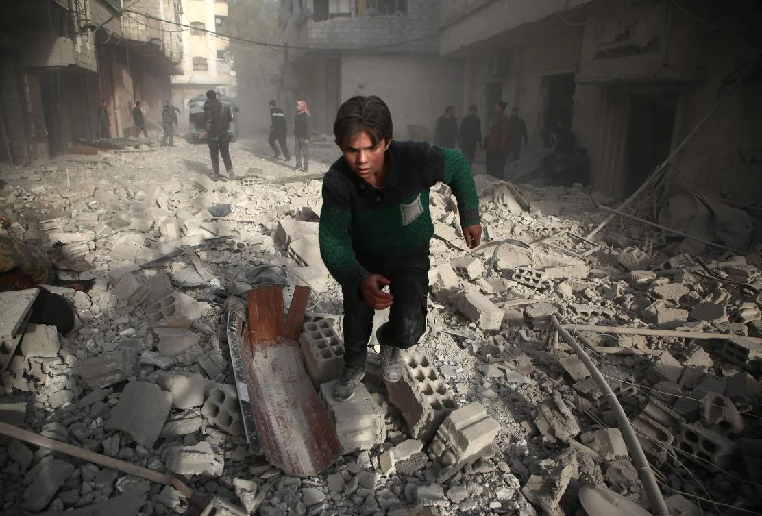 A Syrians youth runs following an air strike in the rebel-held enclave of Arbin in the Eastern Ghouta near Damascus on Feb. 8, 2018. (AFP/Amer Al-Mohibany)