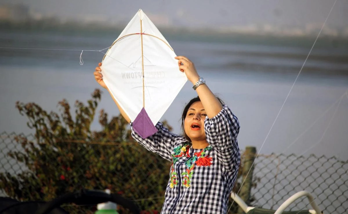 It was a family event, a woman is helping her partner to fly the Kite.