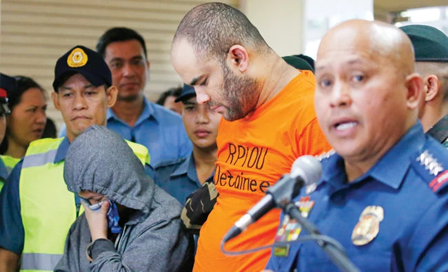 Philippine National Police Chief Gen. Ronald dela Rosa, right, answers questions from the media as he presents arrested foreigner Fehmi Lassoued, also known as John Rasheed Lassoned, allegedly a native of Egypt, along with a Filipino companion Anabel Moncera Salipada, left, Monday. (AP)