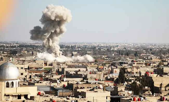 Smoke rises from buildings following bombardment on the village of Mesraba in the rebel-held besieged Eastern Ghouta region on the outskirts of the capital Damascus, on Monday. (AFP)