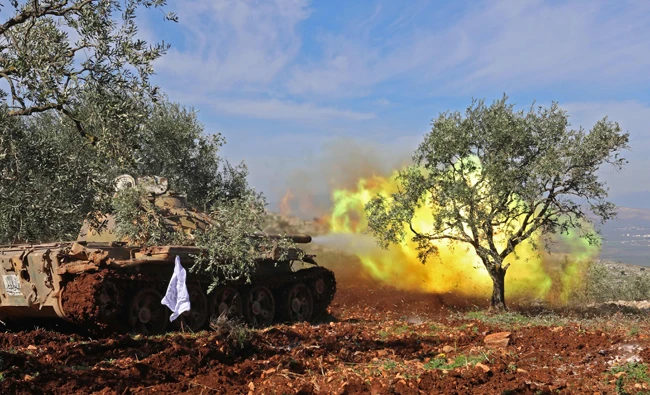 Turkish-backed Syrian rebel fighters fire from the town of Salwah, less than 10 kilometres from the Syria-Turkey border, towards Kurdish forces from the People's Protection Units (YPG) in the Afrin region. (AFP)