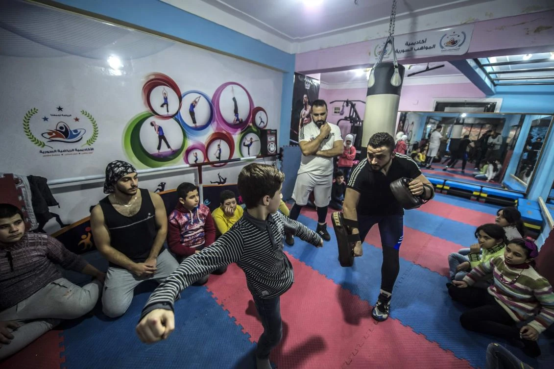 Syrian refugee Amir al-Awad (R) watches as Adel Bazmawi (L) teaches martial arts to a youth at the academy in Egypt's second city of Alexandria on January 4, 2018. (AFP)