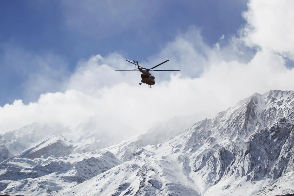 A photo provided by Tasnim News Agency shows a rescue helicopter flying over the Dena mountains while searching for wreckage of a plane that crashed on Sunday. (Tasnim News Agency via AP)