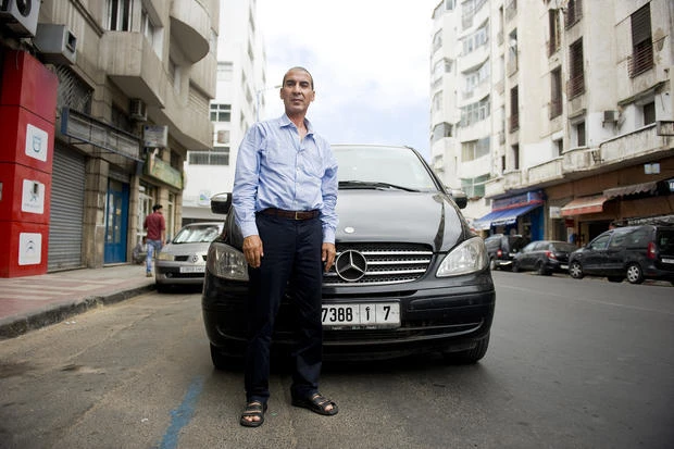 An Uber driver stands in front of his car in Casablanca. Uber said ‘as long as there is no real reform ... we are forced to suspend our operations’ in the country. (MEE)
