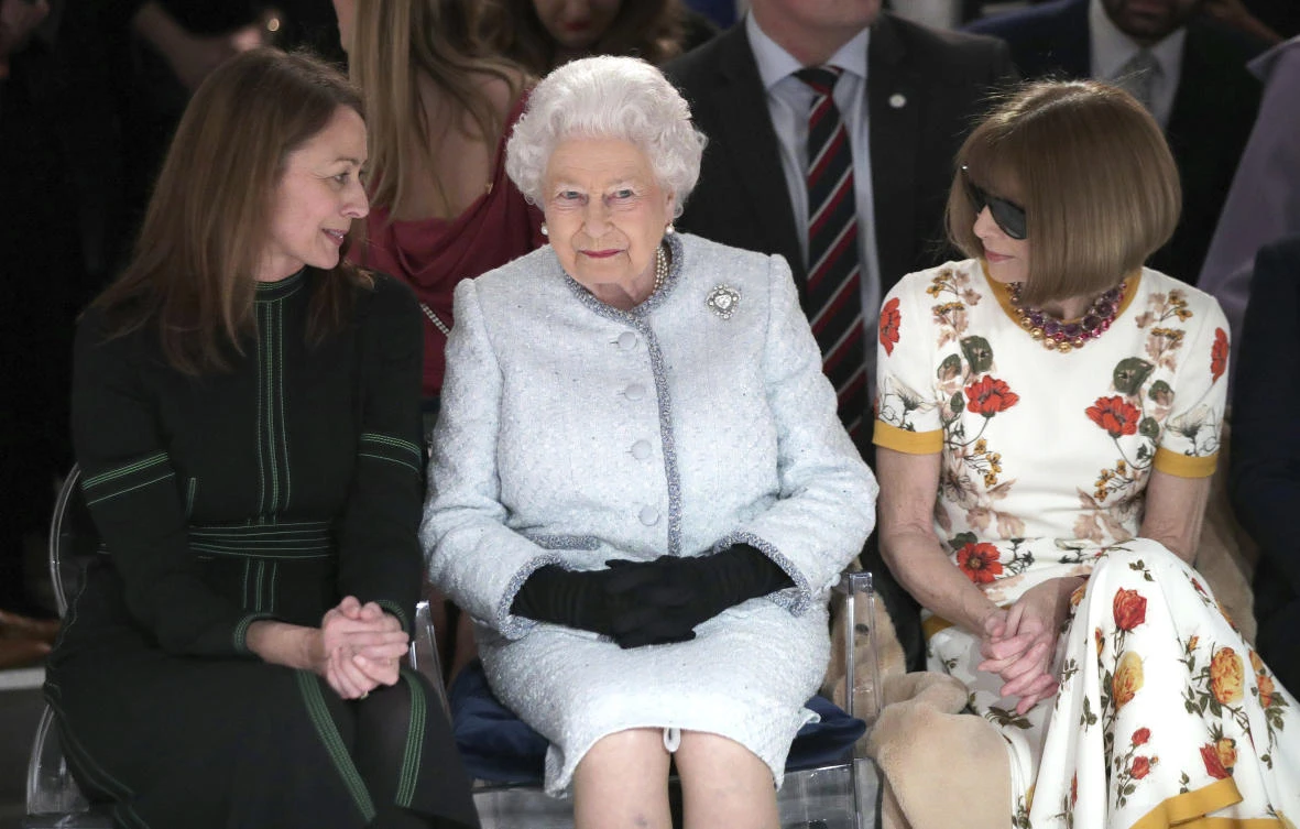 Britain's Queen Elizabeth sits next to fashion editor Anna Wintour, right, and Caroline Rush, chief executive of the British Fashion Council (BFC) as they view Richard Quinn's runway show at London Fashion Week. (AP)