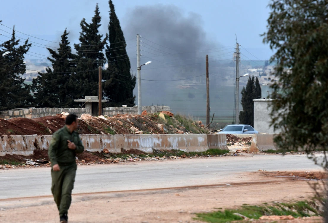 A picture taken on Feb. 20, 2018 shows a Kurdish fighter evacuating following Turkish artillery bombardment near the Afrin crossing in the northern Syrian region, after Syrian pro-government forces entered the region. (George Ourfalian/AFP)