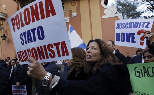 A woman holds a banner reading in Italian "Poland, negationist country" during a protest in front of the Polish embassy in Rome on Feb. 8, 2018. (AP Photo/Alessandra Tarantino)