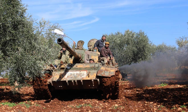 Turkish-backed Syrian rebel fighters are seen in the town of Salwah, less than 10 kilometres from the Syria-Turkey border, ahead of firing towards Kurdish forces from the People's Protection Units (YPG) in the Afrin region, on Feb. 19, 2018. (AFP)