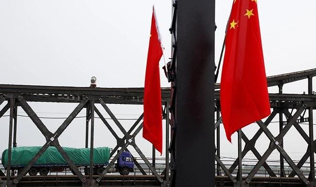 Above, a lorry carrying trade items crosses the friendship bridge from China’s Dandong, Liaoning province to North Korea’s Sinuiju. (Reuters)