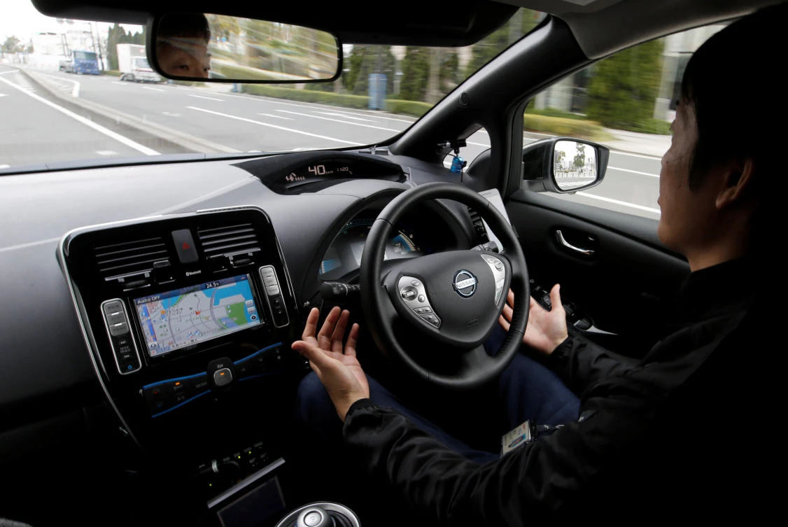 A Nissan employee removes his hands from the steering wheel of a self-driving vehicle for Easy Ride service, developed by Nissan and mobile gaming platform operator DeNA Co. (Reuters)