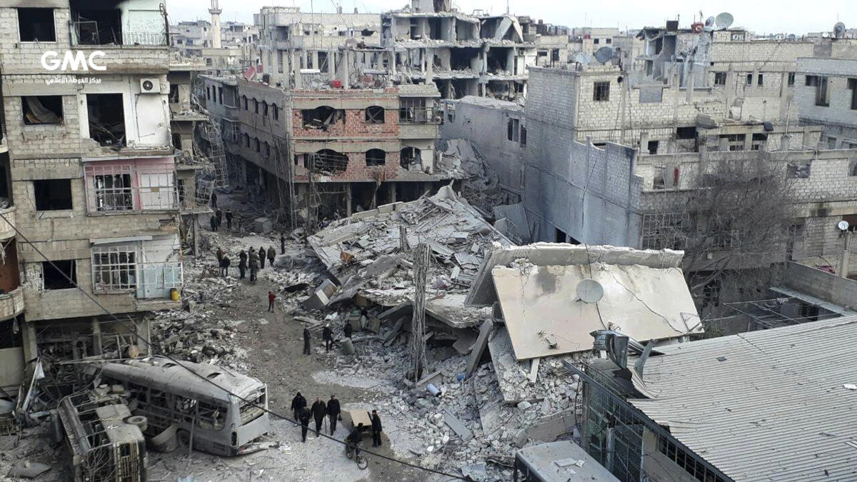 A photo from the Syrian activist group Ghouta Media Center shows Syrians gathering between destroyed buildings during the airstrikes and shelling by Syrian government forces. (Ghouta Media Center via AP)