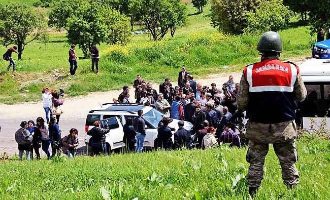 A Turkish gendarme stands guard (R) as Armenian people arrive at a site called "Dudan" near Diyarbakir, and believed to be a mass grave of the Armenian Genocide, for a commemoration ceremony, in this April 22, 2015 file photo. (AFP)