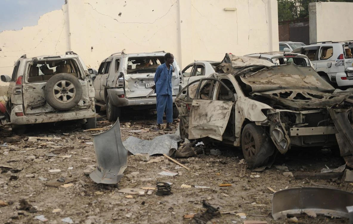 A Somali man stands in the middle of the wreckages of cars as he looks at the scene of a suicide car explosion in front of Doorbin hotel in Mogadishu, on February 24, 2018. (AFP)