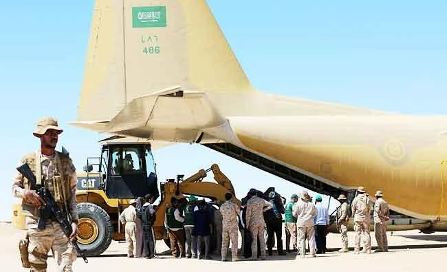 Saudi soldiers stand guard as workers unload aid from a Saudi air force cargo plane at an airfield in Yemen's central province of Marib, in this February 8, 2018 photo. (AFP)