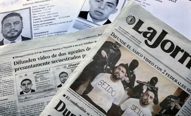Images of federal agents Alfonso Hernandez and Octavio Martinez, who disappeared in the Mexican state of Nayarit on Feb. 5, 2018, appear in the pages of the Mexican newspaper La Jornada and on missing persons posters distributed by the Attorney General of Mexico. (AP)