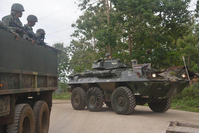 Philippine marines aboard an Amored Personnel Carrier (APC) and a truck guard a highway in Indanan town, Sulu province on the southern island of Mindanao on February 27, 2017. (AFP)
