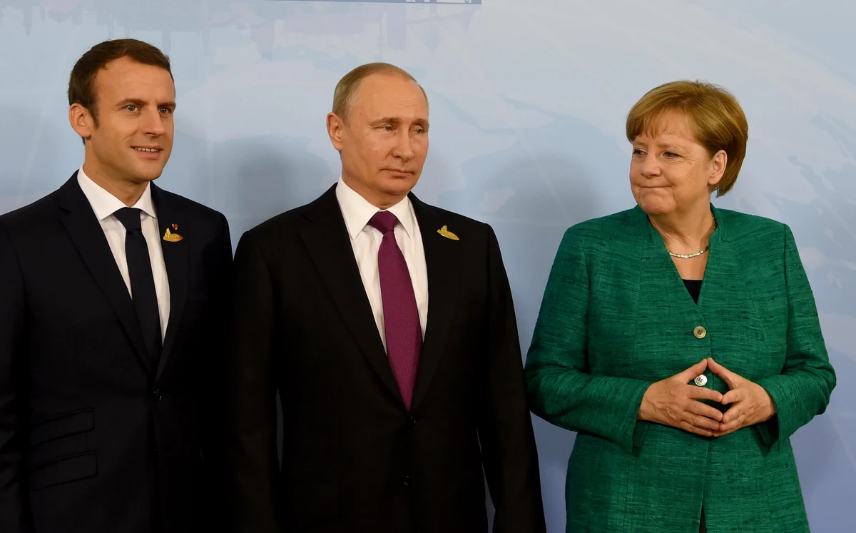German Chancellor Angela Merkel poses with French President Emmanuel Macron (L) and Russia’s President Vladimir Putin (C). The three leaders agreed to exert “maximum pressure” on Syria for an “immediate” implementation of a UN cease-fire. (File Photo: AFP)