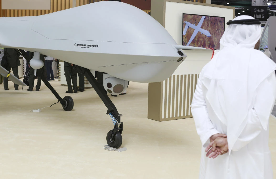 An Emirati stands near a General Atomics Predator XP drone on display at a drone conference in Abu Dhabi. The UAE on Sunday opened a stand-alone trade show featuring military drones called the Unmanned Systems Exhibition & Conference, showing the power the weapons have across the Middle East. (AP)