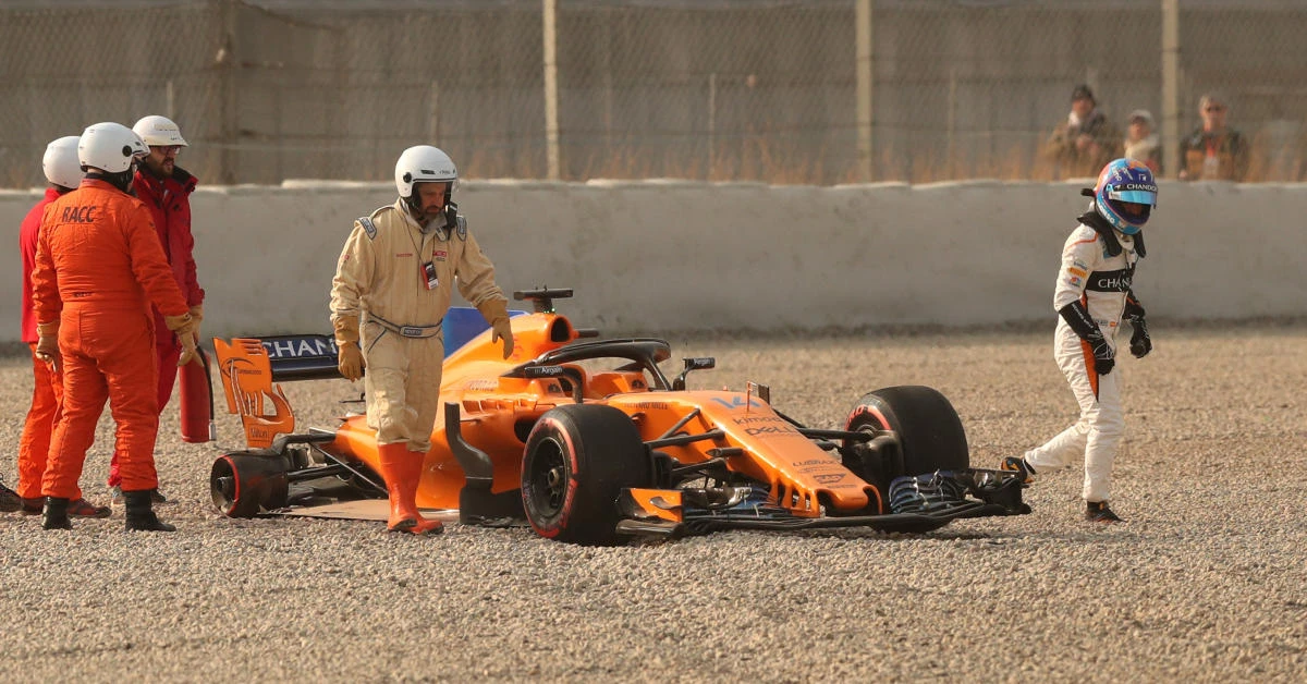 Fernando Alonso of McLaren walks away from his car after a tire fell off during testing. (Reuters)
