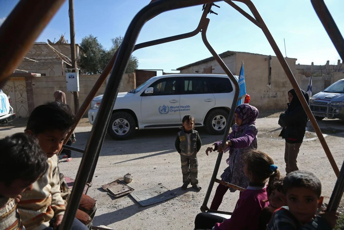 Syrian children play in the street as a United Nations and Syrian Red Crescent inter-agency aid convoy arrives in the town of Utaya, in the Syrian rebel enclave of Eastern Ghouta, on February 14, 2018. (AFP)
