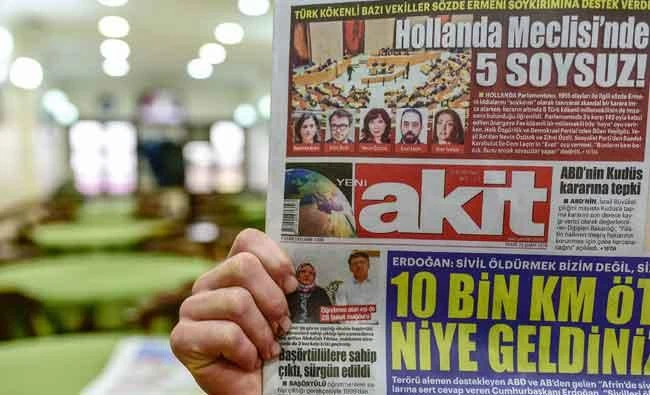 A man reads the Pro-government newspaper Akit with on the front page a title reading "Five bastards at the Dutch parliament!", on Sunday in Istanbul. (AFP)