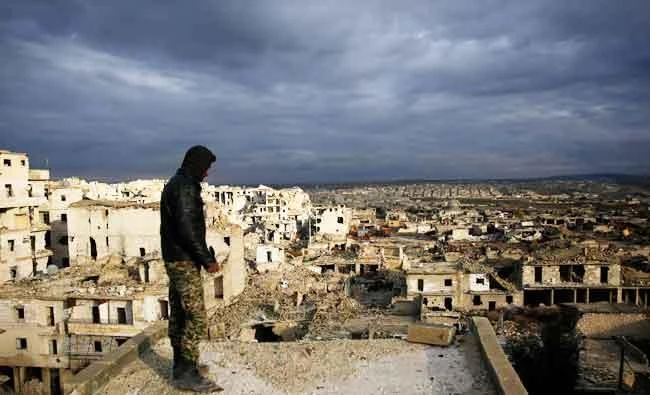 In this Jan. 19, 2018 photo, a soldier looks at the destruction of the Ramouseh neighborhood from a the roof of a damage, in eastern Aleppo, Syria. (AP)
