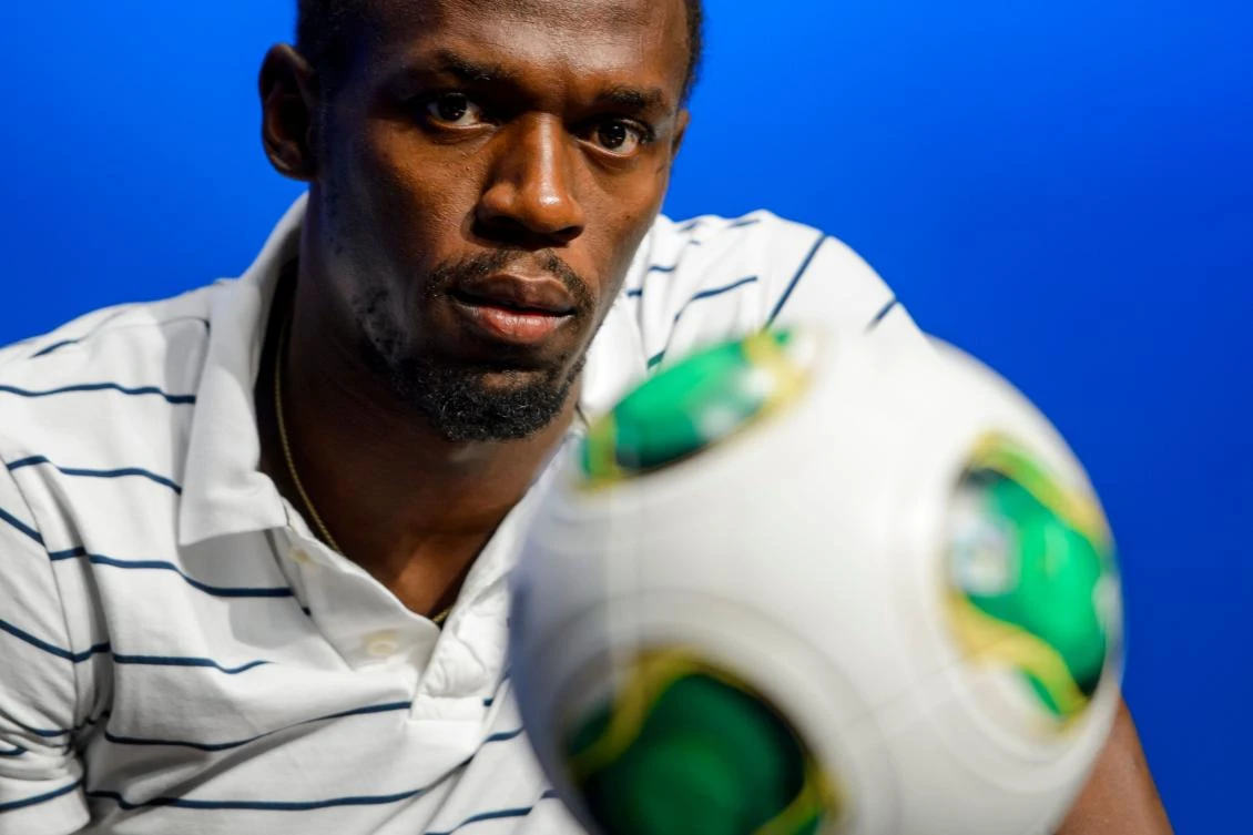Above, Usain Bolt looks on behind a ball during a press conference following his visit at the FIFA headquarters on August 28, 2013. The football-loving Jamaican Olympic sprinter will lead the Soccer Aid World XI to a June charity match to raise funds for Unicef. (AFP)