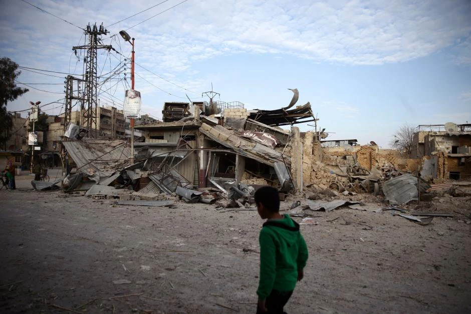 A child walks near damaged buildings in the besieged town of Douma, Eastern Ghouta, Damascus, Syria Feb 20, 2018. (Reuters)Syria’s Ghouta residents ‘wait to die’ as more bombs fall
