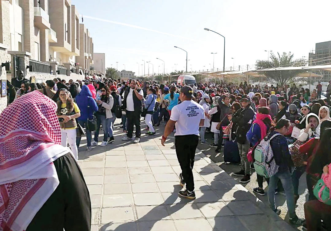 Filipino workers trying to get amnesty waiting outside the Philippine Embassy in Kuwait City. Philippine president earlier this month announced a departure ban for Filipinos planning to work in Kuwait, after the murder there of 29-year-old Joanna Demafelis. (AFP)