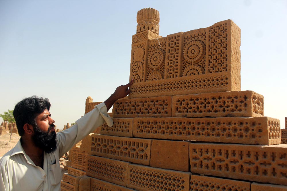 Muhammad Jamshed, a caretaker, explains a design on a tomb at Chaukhandi Islamic Cemetery (Photo Arab News/ M.F. Sabir)
