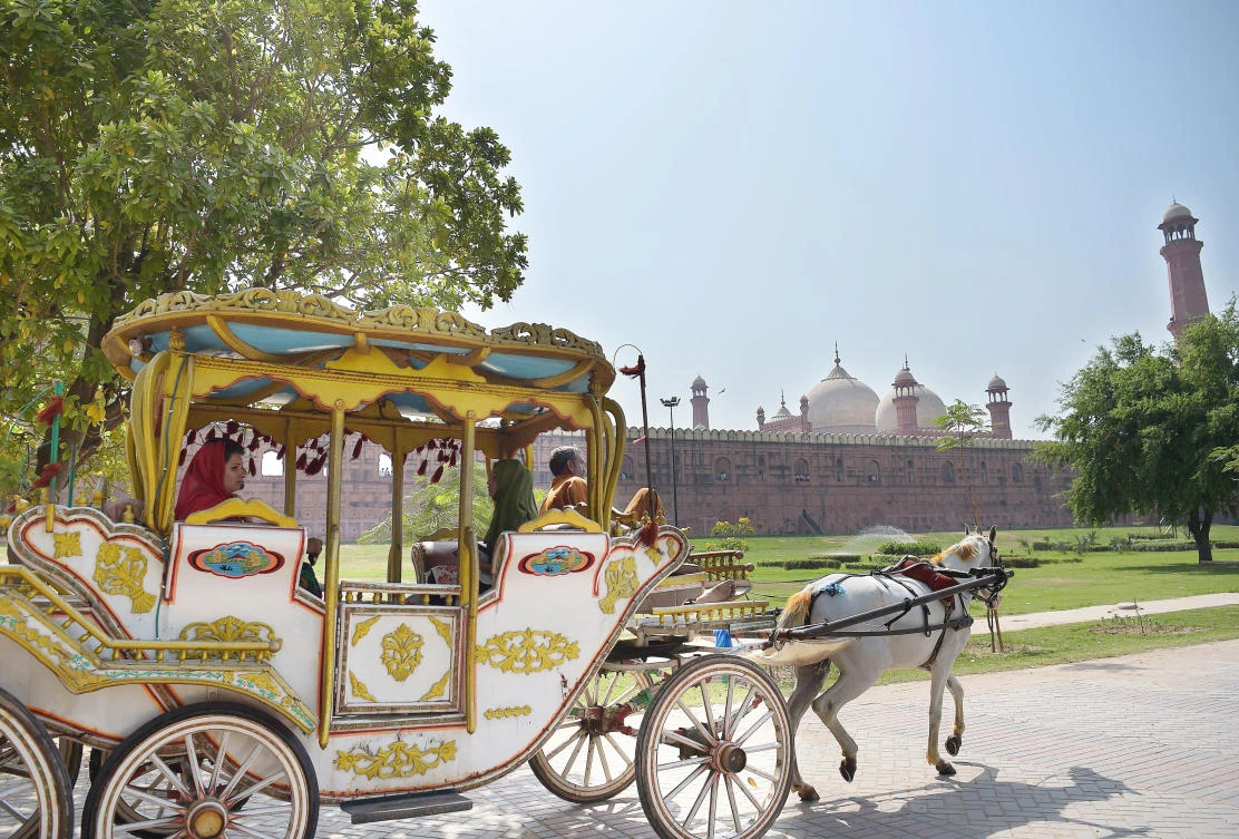 Tourists ride on a horse buggy as they look at the historic Badshahi Mosque in Lahore. (AFP)