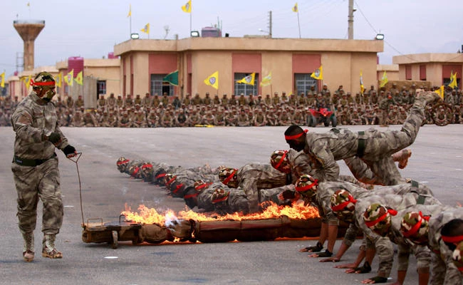 Arab and Kurdish fighters from the Self-Defense Forces take part in a graduation ceremony on March 1, 2018, in the Qamishli region. The US is known to have military outposts and airstrips in Kurdish-controlled areas of Syria. (AFP / Delil Souleiman)