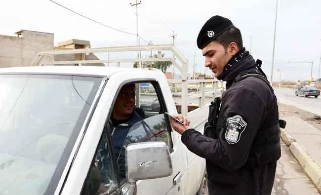 An Iraqi policeman checks the ID of a driver at a checkpoint in Mosul, in this February 22, 2018 photo, seven months after Iraqi forces retook the northern city from Daesh terrorists. (AFP)