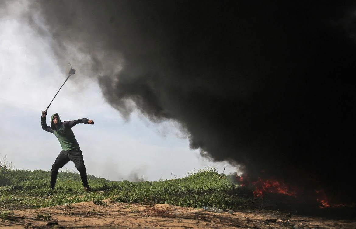 A Palestinian protester throws rocks with a slingshot during clashes with Israeli forces near Khan Yunis by the border between Israel and the Gaza strip on March 2, 2018. (AFP)