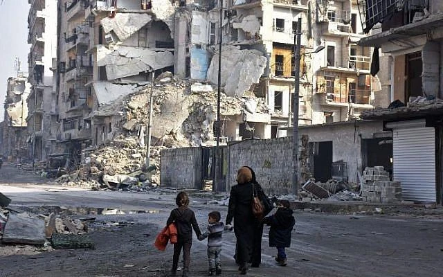 Syrians walk along a damaged street in Aleppo's Tareeq Al-Bab neighborhood on January 18, 2017, a month after government forces retook the northern Syrian city from rebel fighters. (AFP)