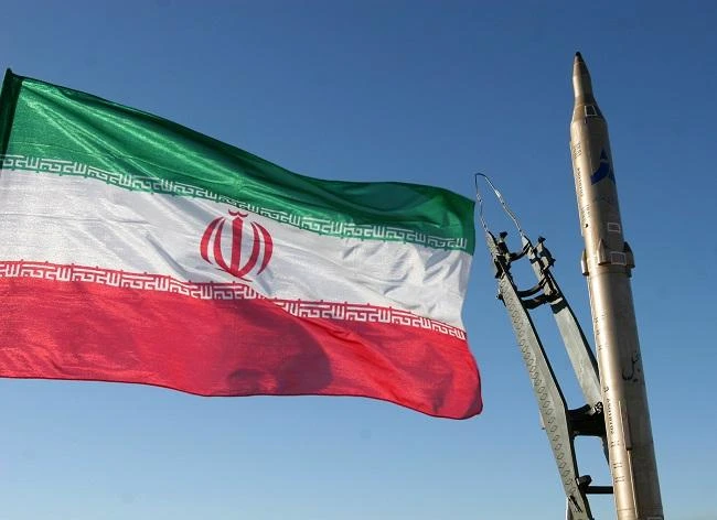 An Iranian flag flutters next to a ground-to-ground Sajil missile before being launched at an undisclosed location in Iran. (File Photo: AFP)