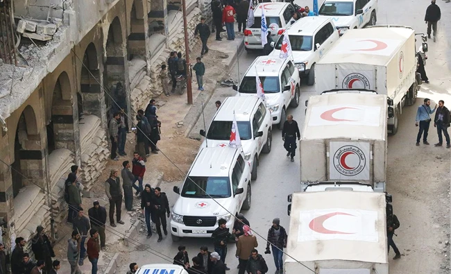 Trucks from Syrian Red Crescent and humanitarian partners are seen in Ghouta, Syria, on Monday in this photo obtained from social media. (REUTERS)