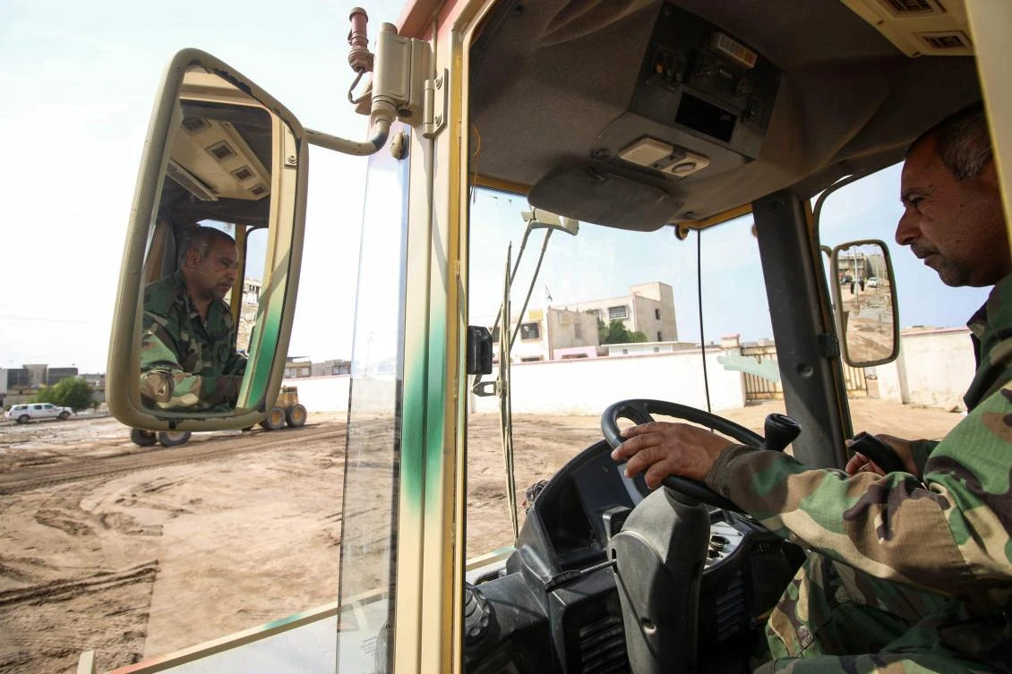 A member of the Hashed al-Shaabi (Popular Mobilisation Forces) operates a road roller marked with camouflage paint in the southern city of Basra on March 1, 2018. Tens of thousands of Iraqis mobilised in 2014 and formed the Hashed al-Shaabi, a paramilitary umbrella organisation set up to fight Daesh, in response to a call by the country's top Shiite authority, Ayatollah Ali Sistani. (AFP/Haidar Mohammed Ali)