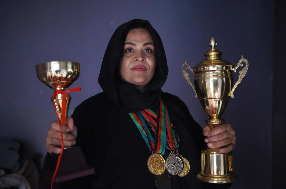 In this Photo taken on March 4, 2018, Afghanistan national powerlifting team member Rasheda Parhiz (L), 40, poses for a picture with her trophies and medals at her home in Kabul.(AFP)