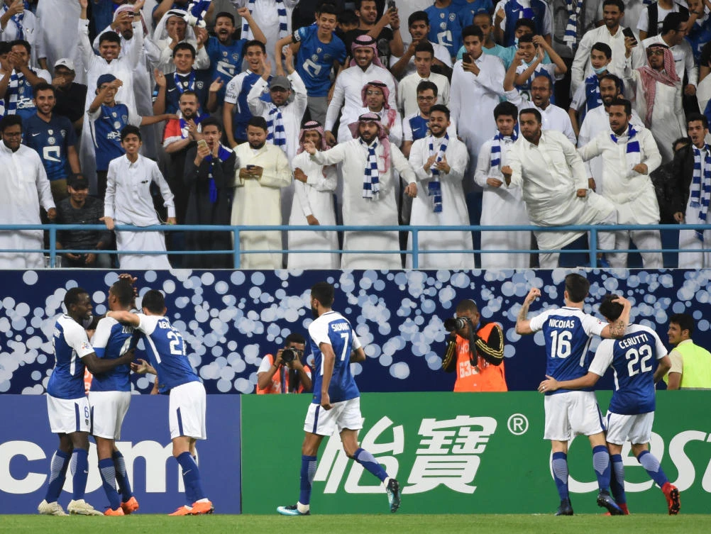 Al-Hilal's players celebrate their equalizer against Al-Rayyan at the King Saudi University stadium in Riyadh on Tuesday. (AFP)