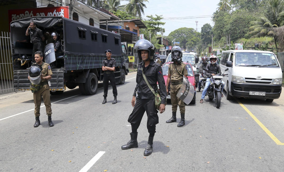 Sri Lankan police officers stand guard in Ambatenna, in central Sri Lanka, Wednesday, March 7, 2018. Sri Lanka’s president declared a state of emergency Tuesday amid fears that anti-Muslim attacks in several central hill towns could spread. The emergency announcement came after Buddhist mobs swept through the towns outside Kandy, burning at least 11 Muslim-owned shops and homes. (AP/Rukmal Gamage)