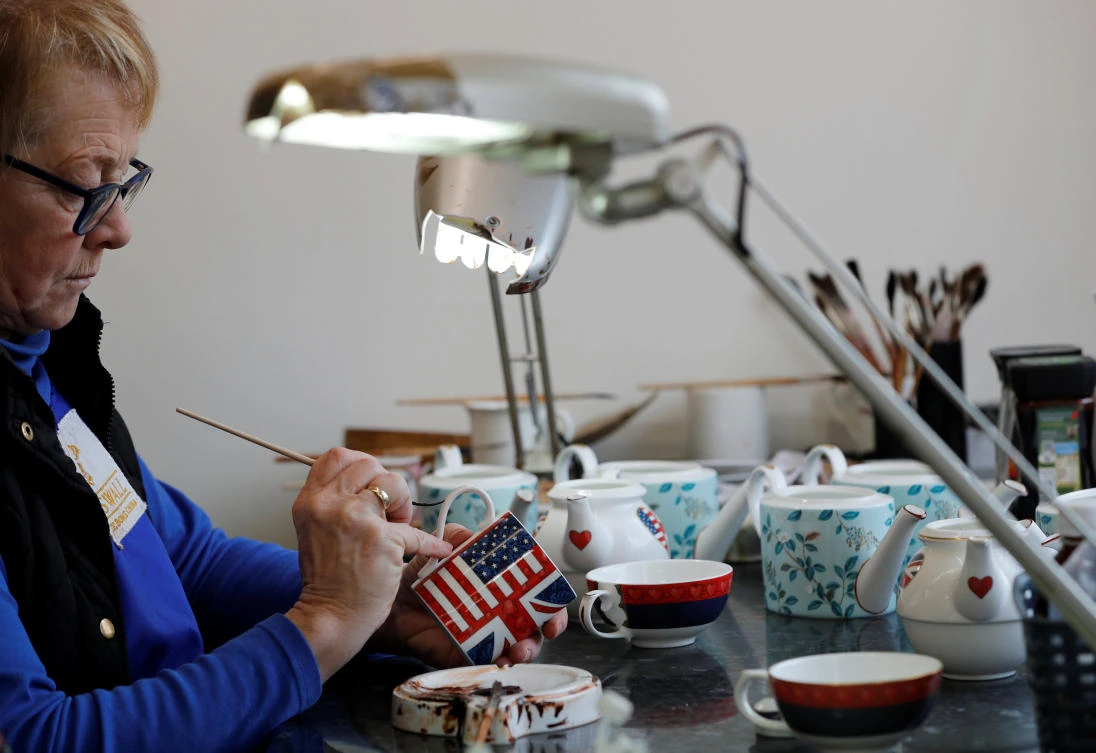 Sue Carter gilds a mug made to celebrate the Royal Wedding between Prince Harry and Meghan Markle at Halcyon Days’ Caverswall factory in Stoke-on-Trent. (Reuters)
