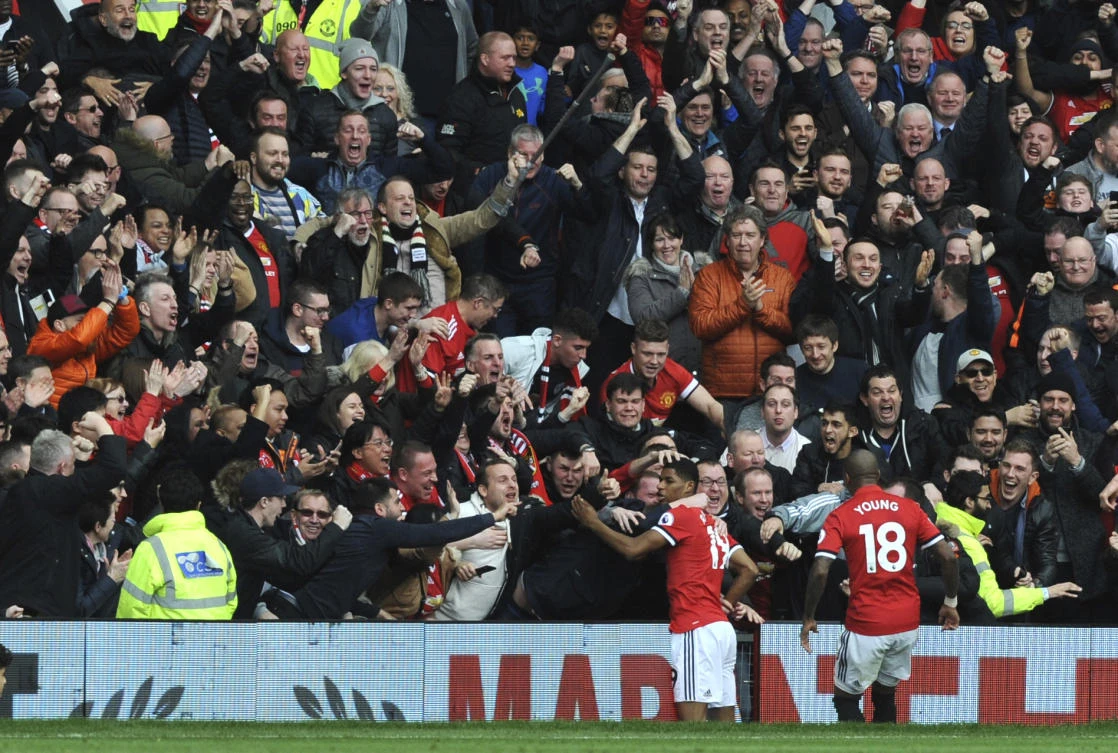 Manchester United's Marcus Rashford celebrates with fans after scoring his sides first goal during the English Premier League soccer match between Manchester United and Liverpool at Old Trafford. (AP)