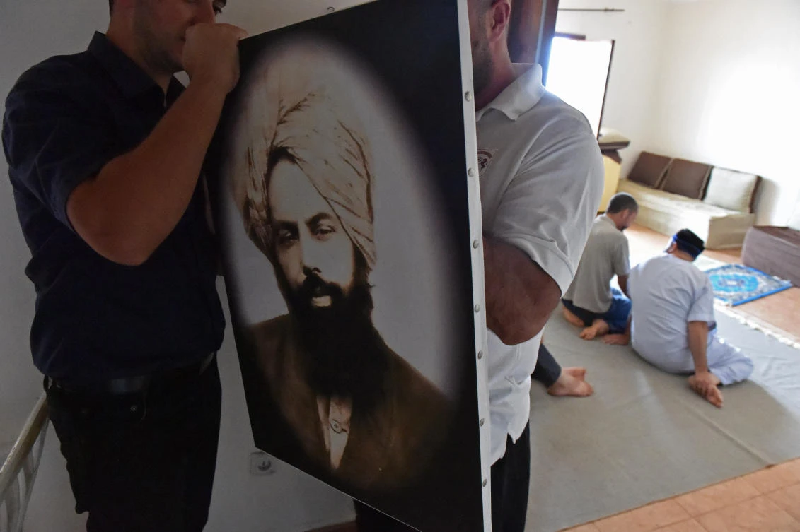 Members of Algeria’s small Ahmadi community put up a photo of Mirza Ghulam Ahmad (1835-1908) the founder of the Ahmadiyya movement, an Islamic movement which is accused of heresy by Islamist extremists and targeted by the authorities. (Ryad Kramdi/AFP)