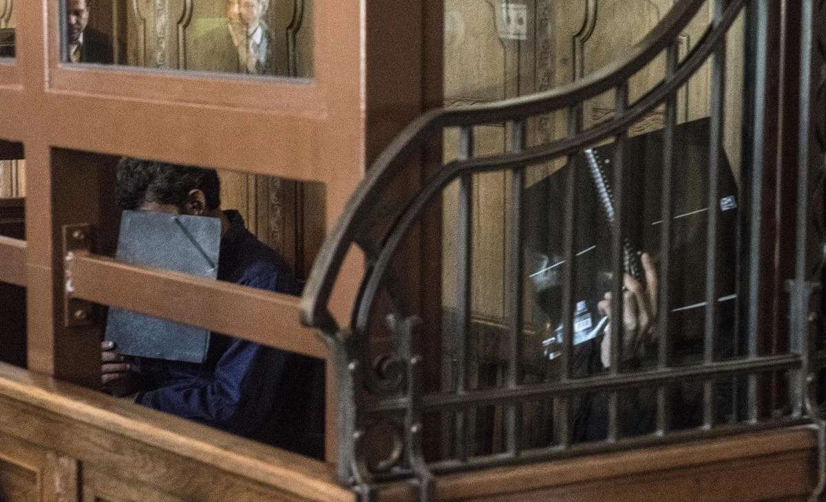 Two defendants hiding their faces, sit in the courtroom of a Berlin court. Two Syrians have gone on trial in Berlin on allegations they fought with terrorist organizations in their home country. (AP)