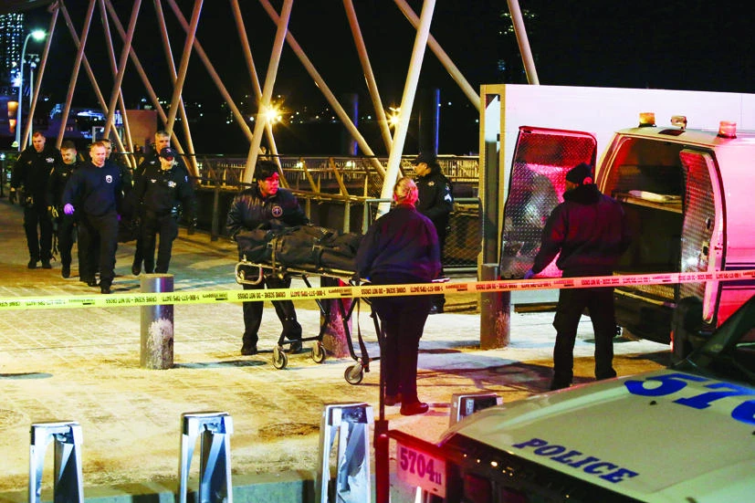 NYPD officers remove the bodies from the scene of a helicopter crash in the East River on Sunday in New York City. (AFP)